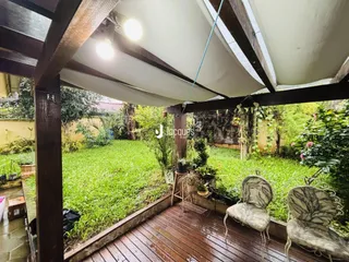 Vista de um jardim com deck de madeira ao ar livre.