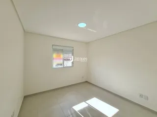 Ambiente interno de uma sala com paredes brancas e piso claro.