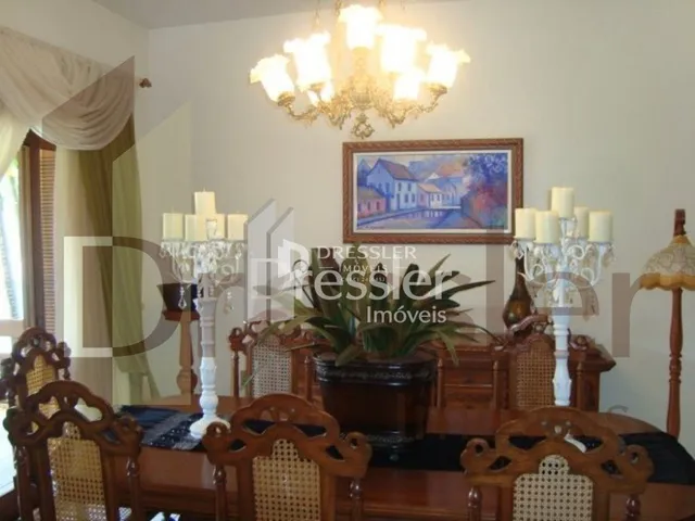 Foto de um ambiente interno com móveis de madeira e lustre decorativo.