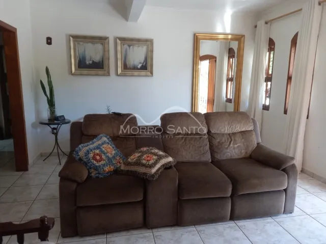 Sala de estar com sofá marrom e parede branca em um imóvel em Lajeado.