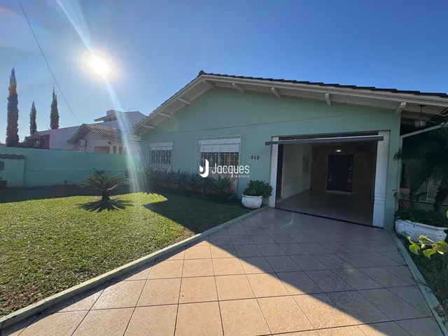 Fachada de uma residência em Lajeado, Brasil, com jardim e área pavimentada.