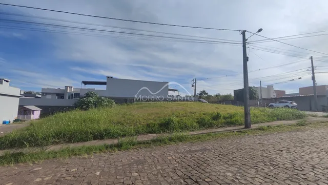 Vista externa de uma propriedade com área gramada em primeiro plano.