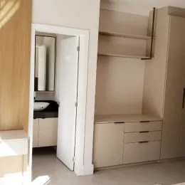 Foto de um interior com paredes brancas e armários em uma passagem.
