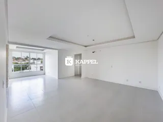 Sala ampla com piso claro e grande janela com vista externa.