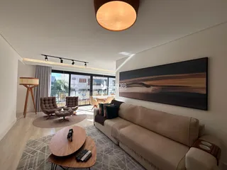 Sala de estar moderna com sofá e decoração de madeira.