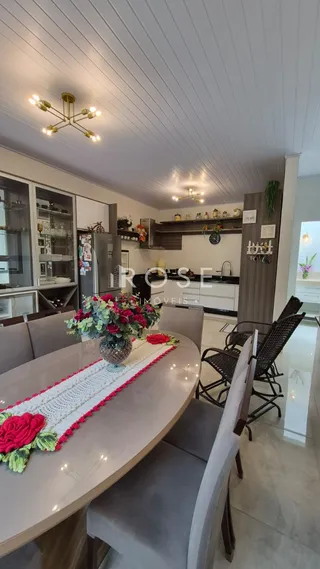 Uma mesa de jantar com arranjo floral em um ambiente interno.