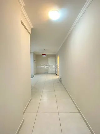 Corredor interno com piso de cerâmica branco.