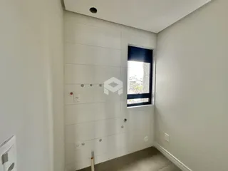 Hall de entrada com paredes brancas e piso claro.
