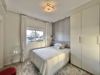 Quarto com cama e armário em um apartamento em Lajeado.