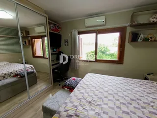 Quarto com janela de madeira e armário embutido.