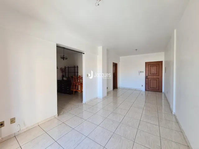 Corredor com piso de cerâmica claro que leva a um cômodo.