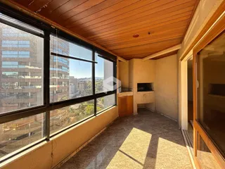 Ambiente interno com grande janela oferecendo vista da paisagem urbana.