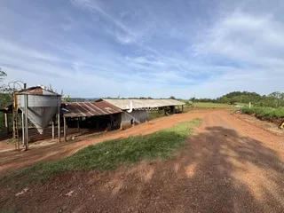 Vista externa de uma propriedade rural com estruturas de armazenamento.