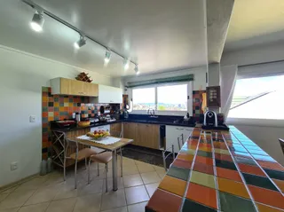 Ambiente interno de uma sala de jantar com piso de cerâmica e armários de madeira.