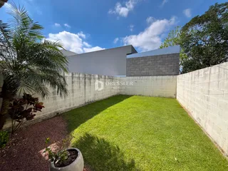 Vista externa de um jardim gramado cercado por muros.