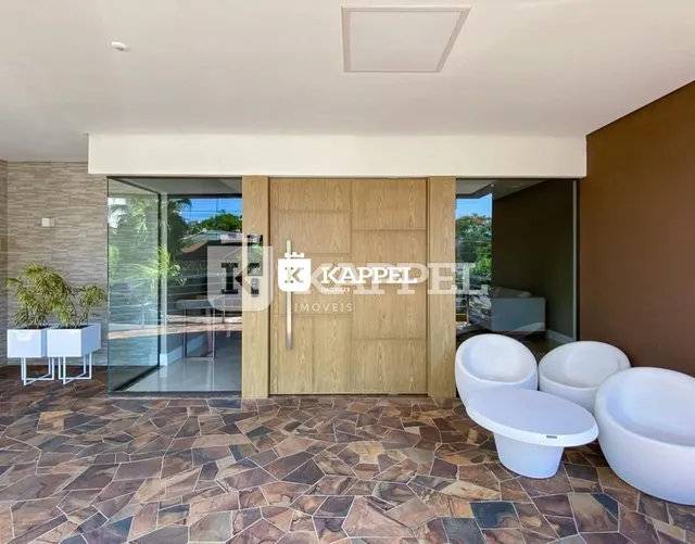 Sala de estar com piso de pedra e portas de madeira, com acesso a uma área externa.