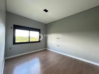 Uma sala de estar com piso de madeira e grande janela.