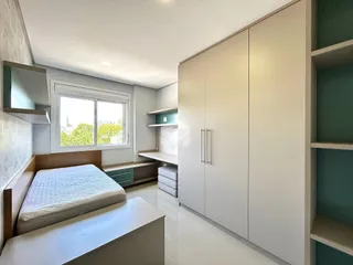 Quarto com cama e armários embutidos em um apartamento.