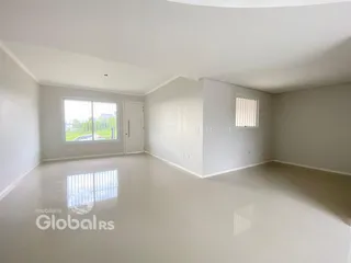Sala ampla e iluminada com paredes brancas e piso claro.