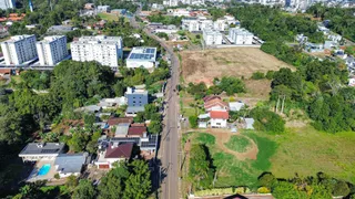 Vista aérea de uma área residencial em Lajeado, Brasil, mostrando casas e vegetação.