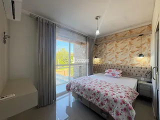 Quarto com cama e porta de vidro abrindo para a área externa.