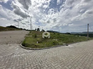 Vista externa de um terreno com grama e pavimentação.