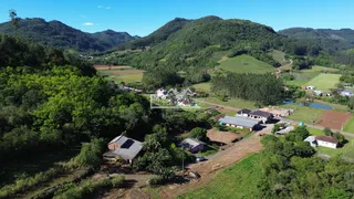 Paisagem de colinas arborizadas com propriedades rurais no Brasil.
