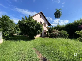 Vista externa de uma residência com jardim gramado.