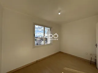 Quarto interno com piso de madeira e janela.
