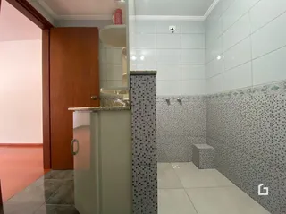 Banheiro com revestimento cerâmico nas paredes e piso.