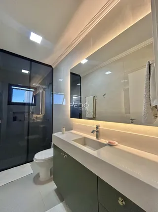 Banheiro moderno com bancada e box de vidro.