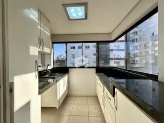 Vista da cozinha de um apartamento em Lajeado, Brasil, com grandes janelas.