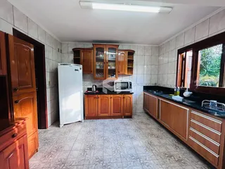 Imagem de uma cozinha com armários de madeira e piso de cerâmica.