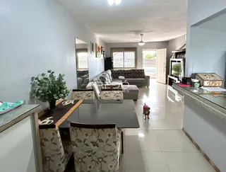 Sala de estar com sofá e mesa de jantar em um imóvel no Brasil.