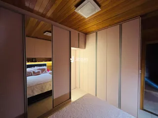 Quarto com paredes claras e teto de madeira no imóvel em Lajeado.