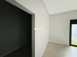 Vista interna de um ambiente com paredes brancas e piso claro.
