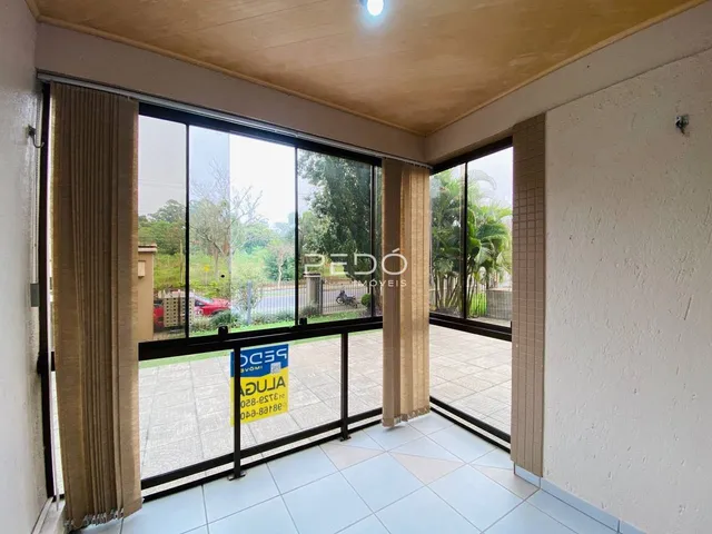 Vista de uma sala de estar com grandes portas de vidro que dão acesso a um pátio externo.