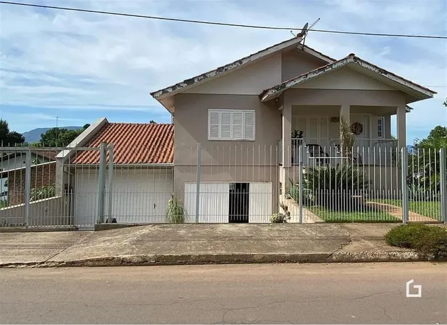 Fachada de uma casa residencial em Lajeado, Brasil, com cerca e portão de metal.