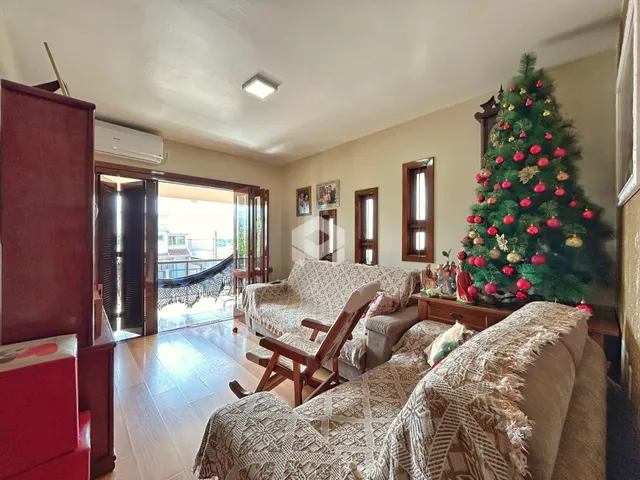A sala de estar apresenta um sofá e uma árvore de Natal decorada.