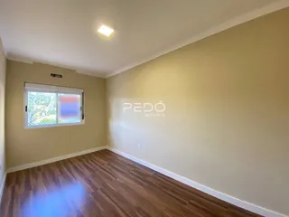 Ambiente interno com piso de madeira e parede clara.