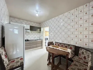 Ambiente interno com paredes brancas e piso claro em uma residência.