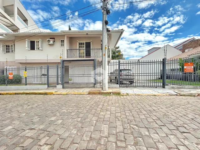 Fachada de uma residência em Lajeado, Brasil, com portão de ferro e cerca.