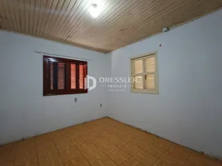 Vista interna de um cômodo com piso de cerâmica e forro de madeira.