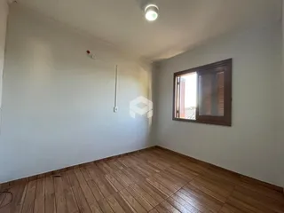 Foto de um ambiente interno com piso de madeira e paredes brancas.