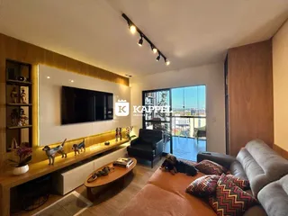 Sala de estar moderna com televisão e vista para a cidade.