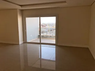 Interior de uma sala com porta de vidro abrindo para uma vista externa.