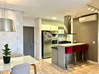 A sala de estar e a cozinha são integradas em um ambiente moderno.