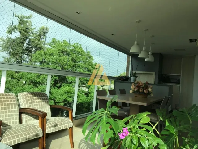 Varanda com grade de vidro oferecendo vista para a vegetação externa.