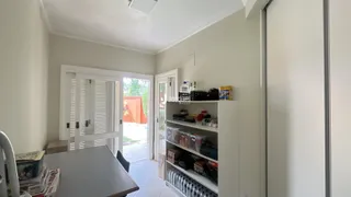Vista interna de uma sala com porta de vidro abrindo para o exterior.