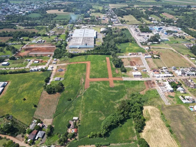 Vista aérea de um terreno rural com áreas de vegetação e construções dispersas.